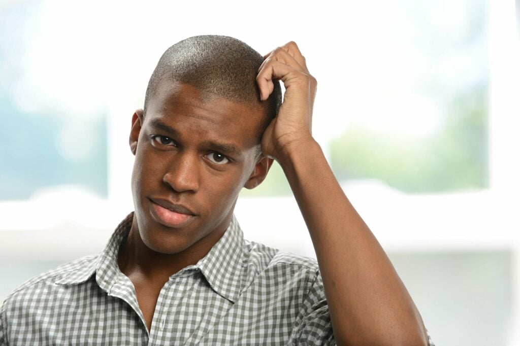 Worried young man with hand on his head 