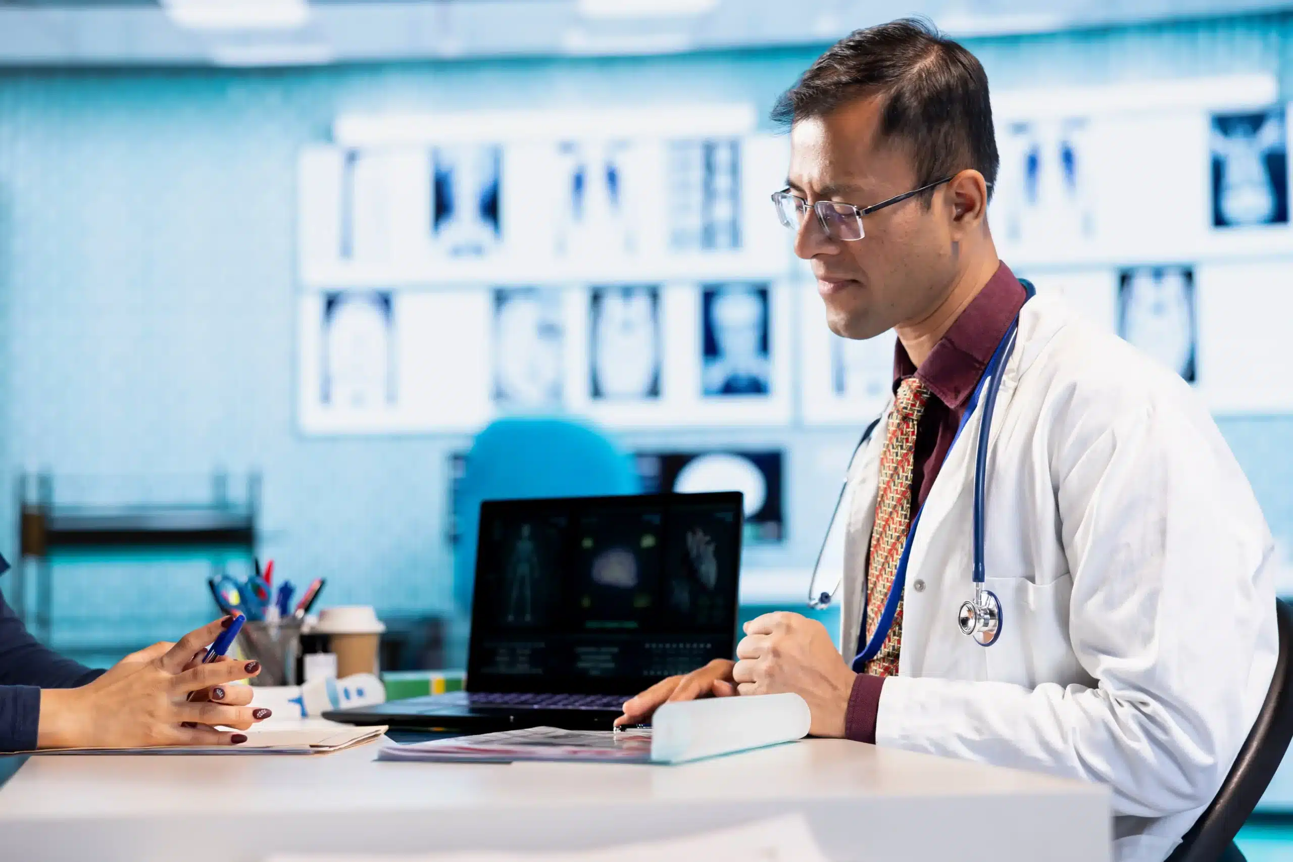 Doctor reviewing X-ray and MRI results with injured worker during independent medical examination for workers’ compensation insurance claim